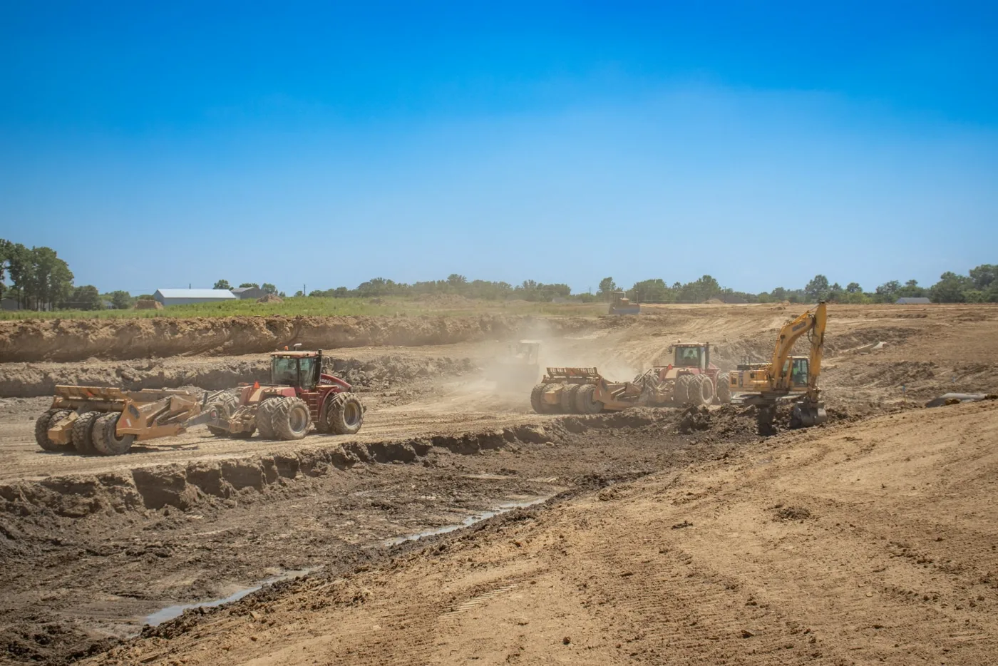 Earthmoving equipment grading a development site